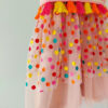 a close up of the lower part of a bright colour confetti spotted children's birthday party dress. This dress is handmade in New Zealand