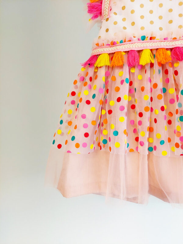a close up a bright colour confetti spotted children's birthday party dress. This dress is handmade in New Zealand