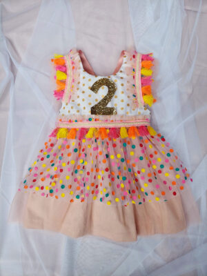 Child's birthday party dress with bright colour confetti spots and number 2 on the front.