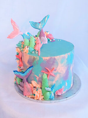 Mermaid-themed birthday cake with fondant tails and ocean decorations by Mane and Tusk, Cambridge NZ
