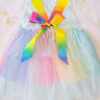 Pastel rainbow children’s occasion dress with sequin rainbow bodice and large rainbow bow at the back