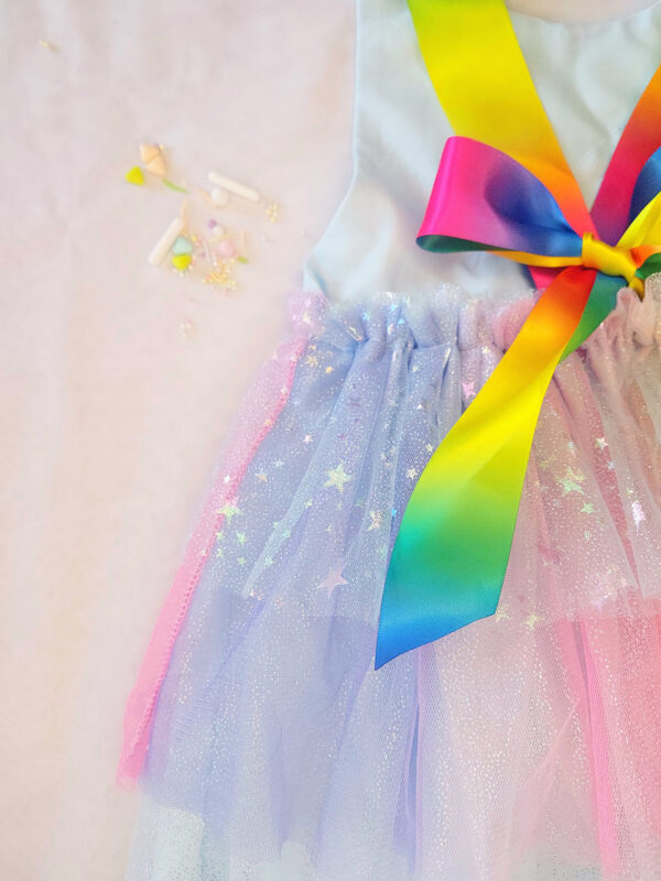 Pastel rainbow children’s occasion dress with sequin rainbow bodice and large rainbow bow at the back