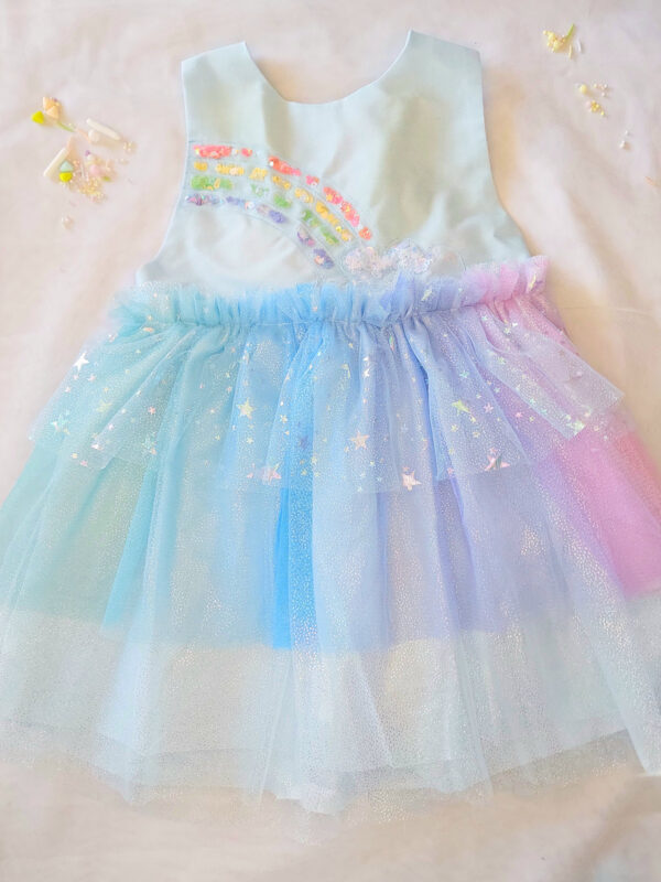Pastel rainbow children’s occasion dress with sequin rainbow bodice and large rainbow bow at the back